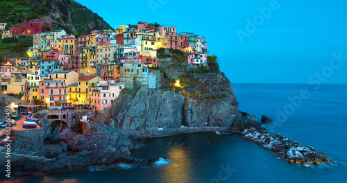 Magical beautiful landscape with bright colored houses on the rock on the sea coast of Manarola in Cinque Terre, Liguria, Italy, Europe in the evening