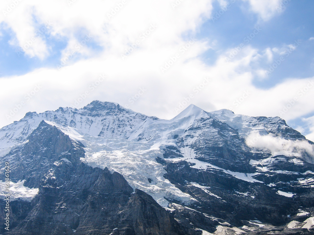Landscape view of snow covered Swiss alp mountains with cloudy sky Landscape view of snow covered Swiss alp mountains with cloudy sky