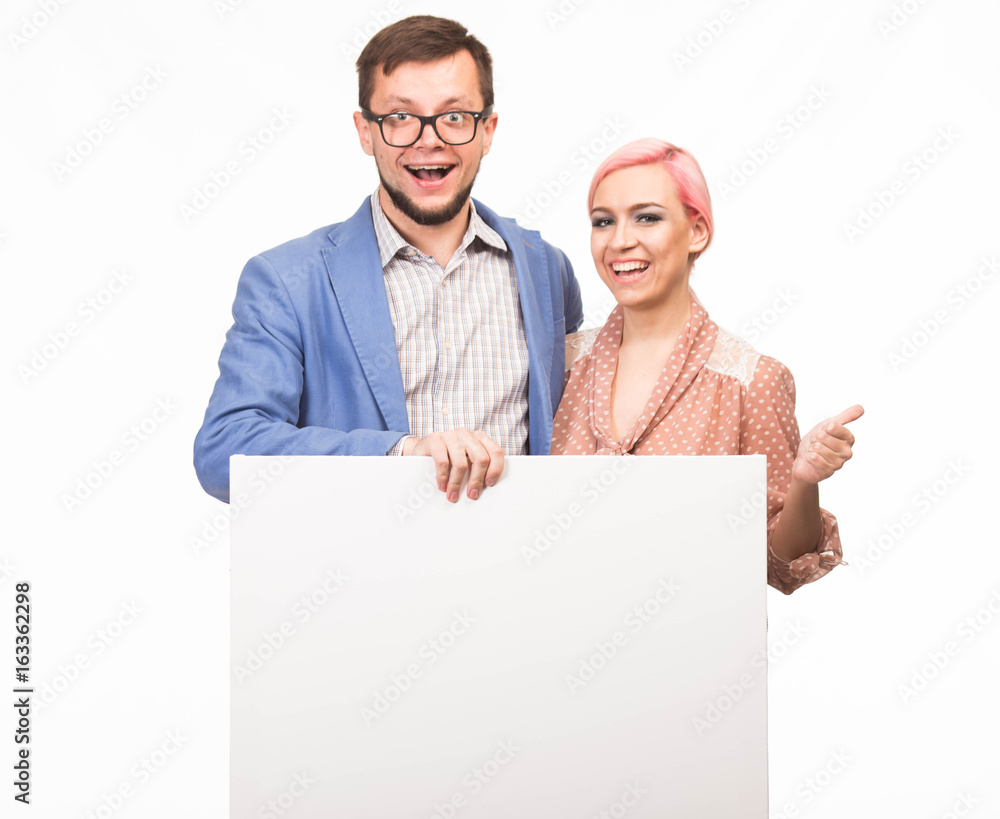 Young happy couple portrait of a confident businessman showing presentation, pointing paper placard background. Ideal for banners, registration forms, presentation, landings, presenting concept. Young happy couple portrait of a confident businessman showing presentation, pointing paper placard background. Ideal for banners, registration forms, presentation, landings, presenting concept.