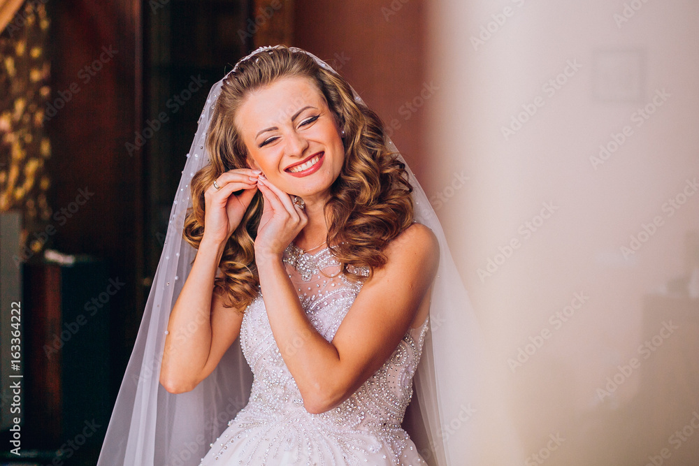 Portrait of beautiful bride model with perfect makeup and hair style in light room in a morning Portrait of beautiful bride model with perfect makeup and hair style in light room in a morning