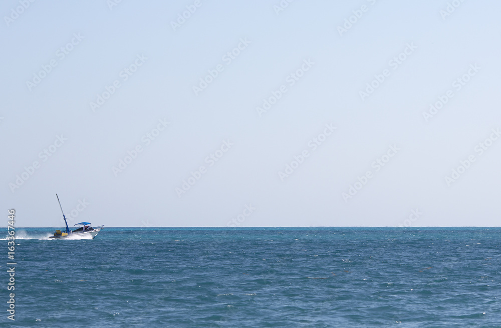 Fototapeta premium Motor boat heading towards the sea. Nothing more but empty horizon. Boat composed to the left where the focus point is. Copy space.