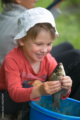 Caught a small fish in children's palms. photo