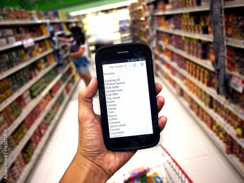 Hand holding a smartphone with grocery list