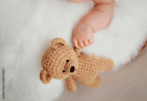 Sweet bear little baby boy playing with his toys at home. Portrait of a lifestyle.