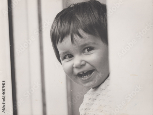 Bambina piccola sorridente da originale degli anni settanta photo