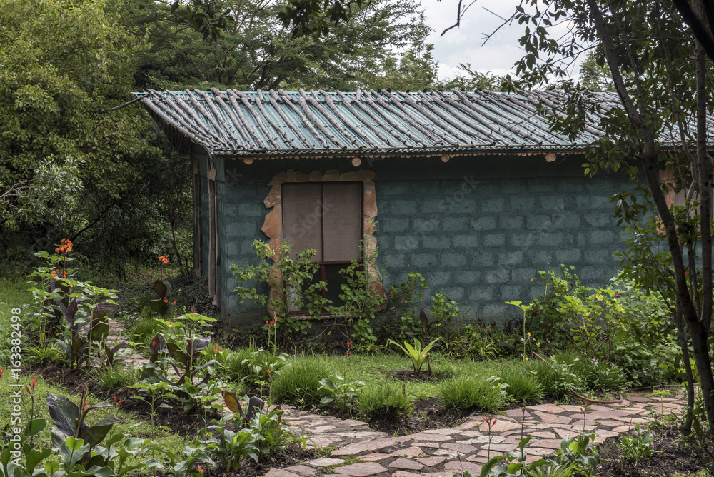 A small, poor village house in the middle of a garden A small, poor village house in the middle of a garden