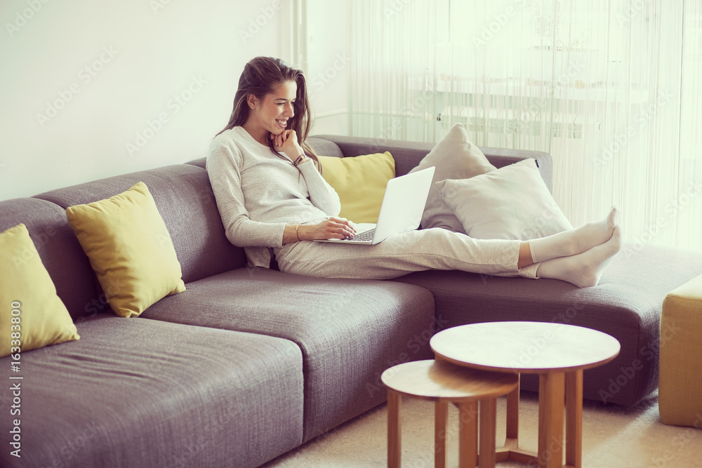 Young woman in living room surfing the internet Young woman in living room surfing the internet