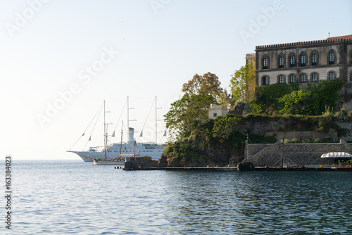 Small and large (cruise) sailing ship anchored in the roadstead in front of Lipari castle
