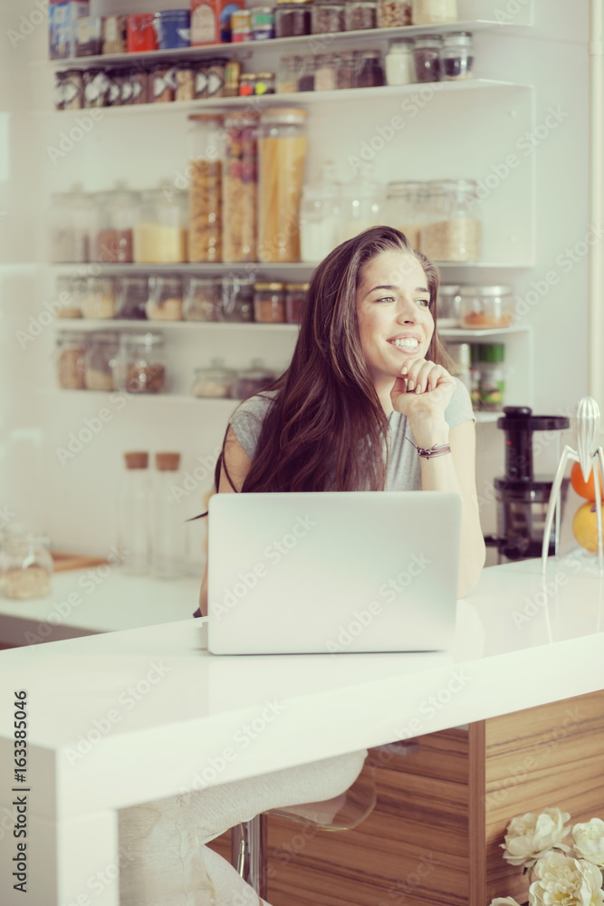 Young woman in kitchen looking for a healthy breakfast recipe Young woman in kitchen looking for a healthy breakfast recipe