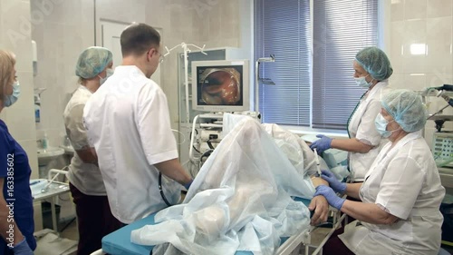 Doctors conducting procedure in endoscopy room photo
