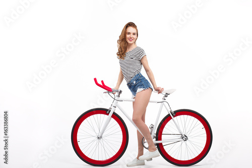 Cheerful girl on bicycle in studio