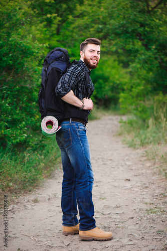 Young Man Traveler with backpack relaxing outdoor. Summer vacations and Lifestyle hiking concept