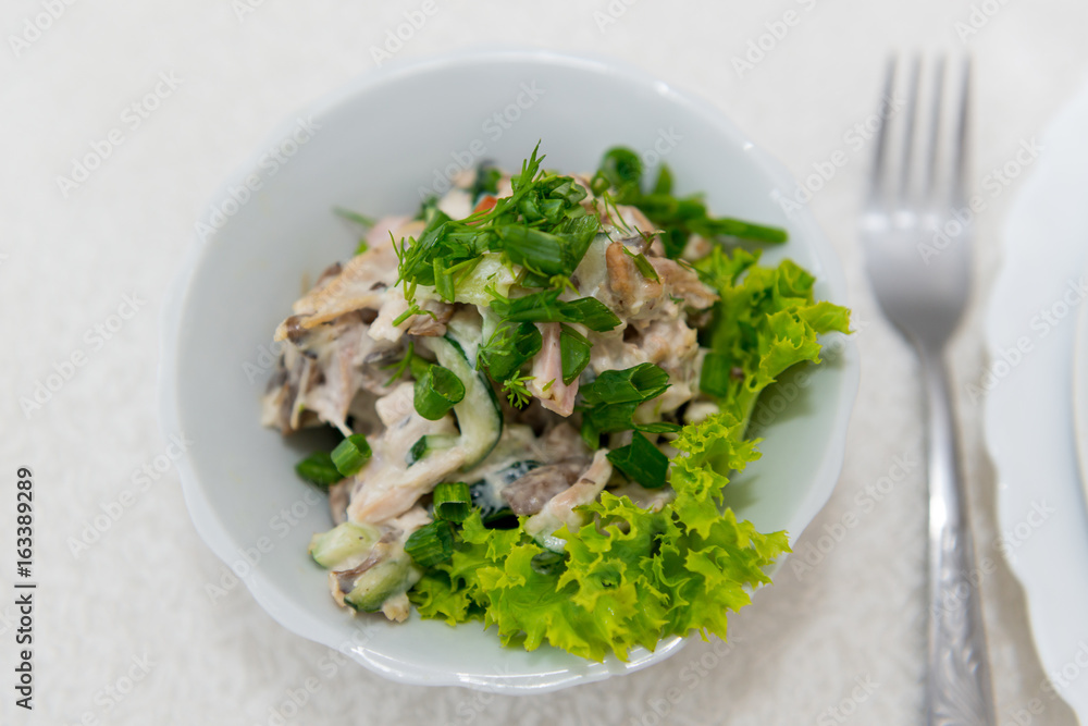 Juicy, delicious meat salad with mushrooms, fresh cucumber and herbs seasoned with close-up sauce.