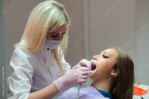 Female dentist examining teeth in dental office
