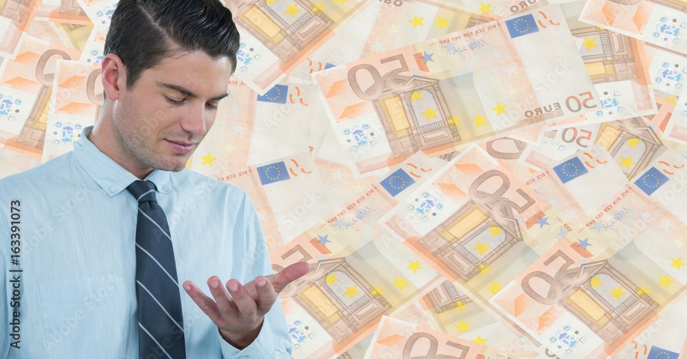 Business man looking at hand against money backdrop Business man looking at hand against money backdrop