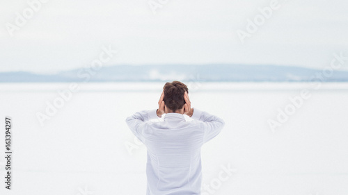 Quadro su tela Le silence est trop fort - Homme qui se cache les oreilles dans un paysage ennei