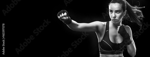 Female boxer fighting. Isolated on black background. Copy Space.