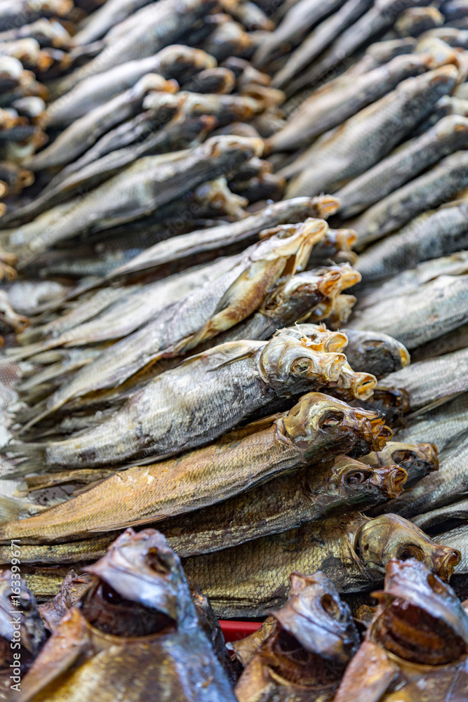 Dried salted fish lies on the counter for sale
