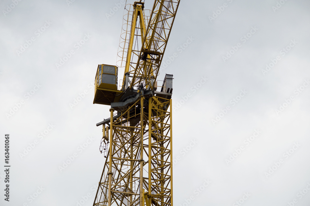Tower crane cabin against the sky. The cockpit of a construction crane Tower crane cabin against the sky. The cockpit of a construction crane