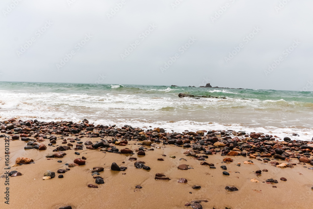 Coast, waves and beach with yellow sand and pebbles Coast, waves and beach with yellow sand and pebbles