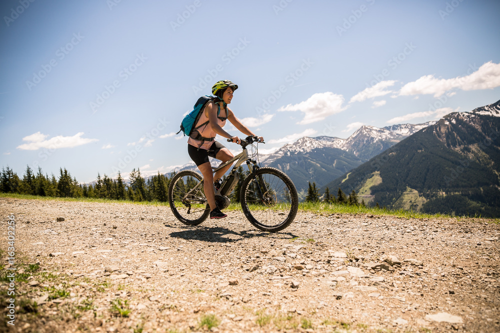 Frau fährt mit Pedelec eine Fahrradtour in den Bergen