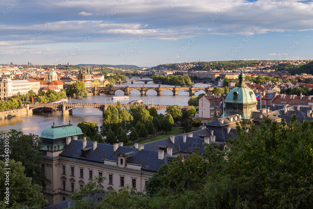 Bridges over Vltava River, Straka Academy and other buildings in Prague, Czech Republic, viewed slightly from above in the daytime.