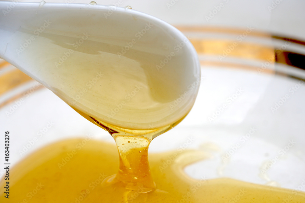 Honey in a plate with a white spoon Honey in a plate with a white spoon