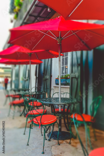 Colorful New Orleans. Red umbrellas of a street cafe © konoplizkaya