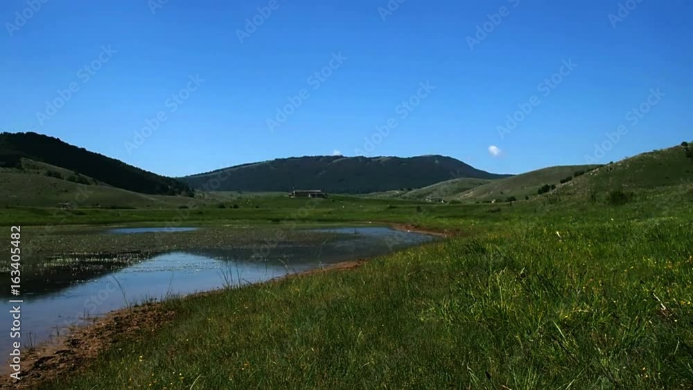 View of mountain lake on a sunny morning, Lake Rascino, June 2017 in Borgorose, Rieti, Italy View of mountain lake on a sunny morning, Lake Rascino, June 2017 in Borgorose, Rieti, Italy