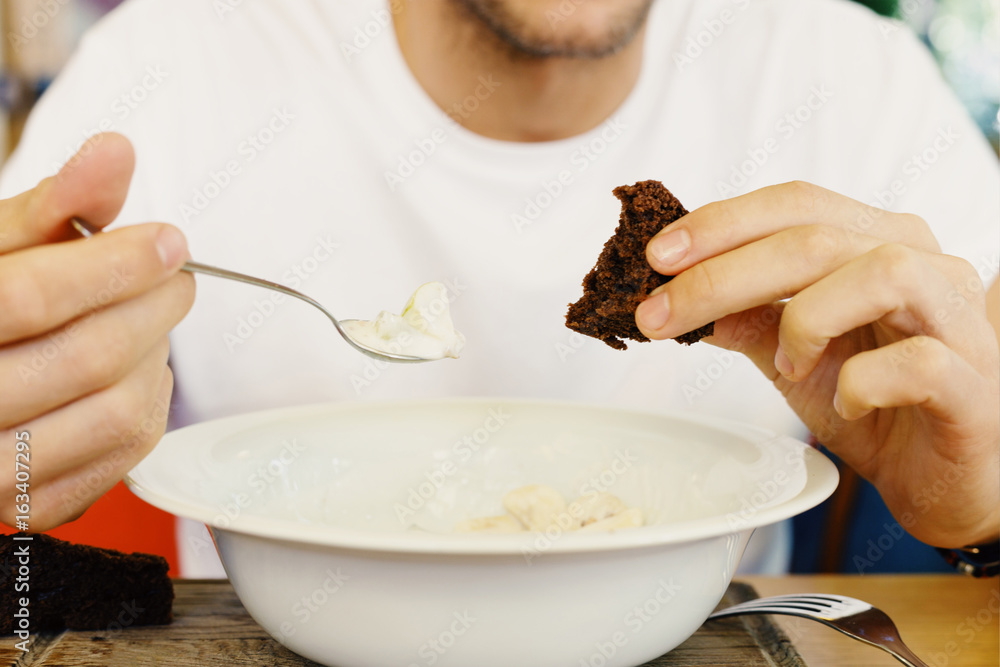 Breakfast at the cafe. Man is eating brown bread and yoghurt Breakfast at the cafe. Man is eating brown bread and yoghurt