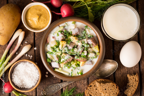 Okroshka. Traditional Russian summer cold yogurt soup in bowl on wooden background.