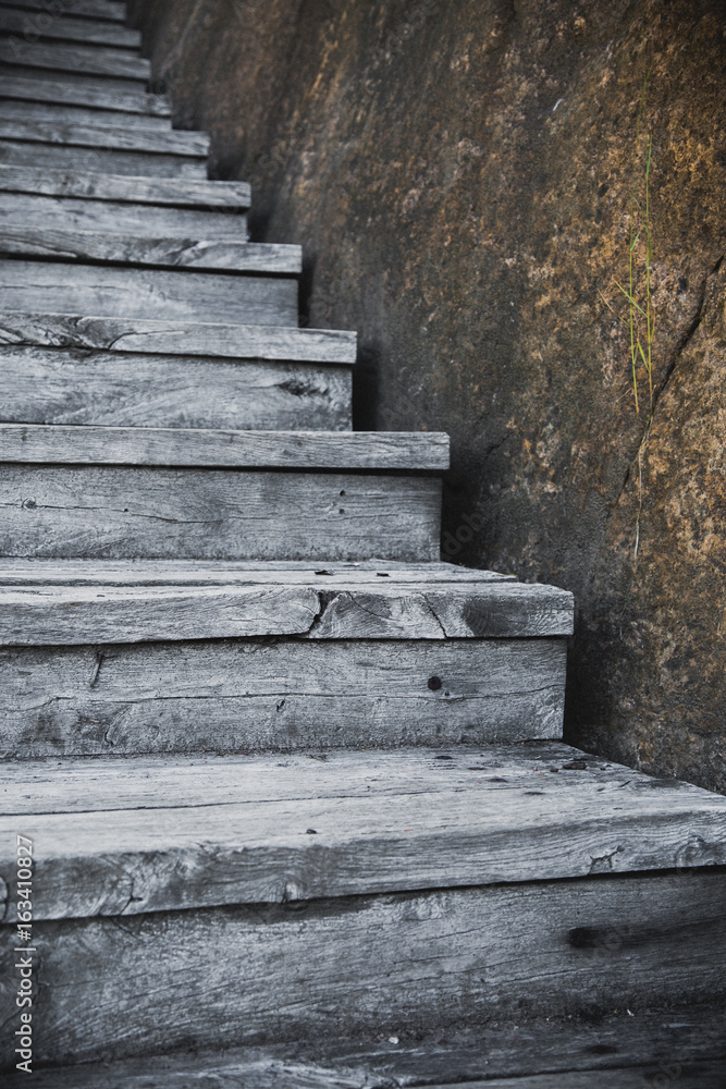Old wooden stairs up outdoors with the stone Old wooden stairs up outdoors with the stone