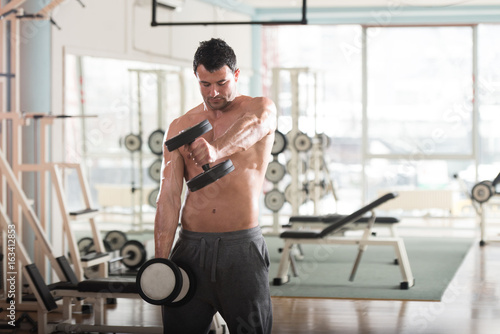 Athlete Exercising Shoulders With Dumbbells