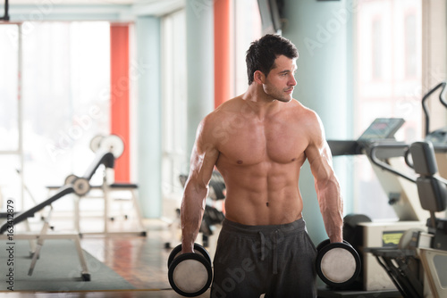 Athlete Exercising Biceps With Dumbbells