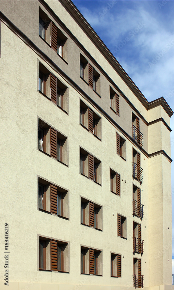 Part of the wall with windows of a modern house on a summer day. View at an angle to the building