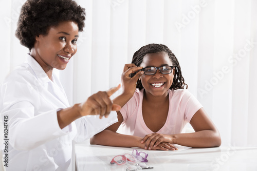 Smiling Girl Wearing Eyeglasses In Front Of Optometrist