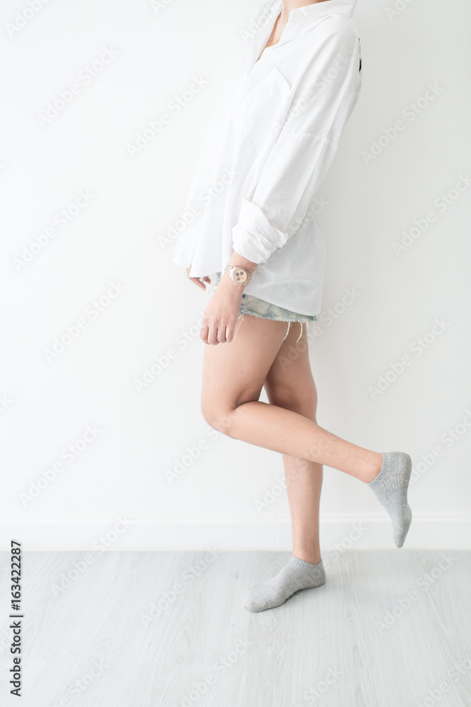 Asian woman wearing white shirt standing on gray wooden floor Asian woman wearing white shirt standing on gray wooden floor