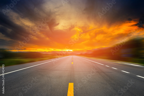 landscape of sunset or sunrise light above asphalt road