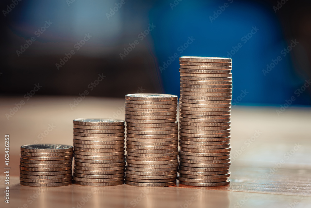 Increasing columns of coins, piles of gold coins arranged as a graph on wooden table. vintage tone. Increasing columns of coins, piles of gold coins arranged as a graph on wooden table. vintage tone.