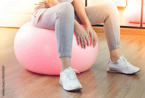 Woman exercise ball flexing in gym