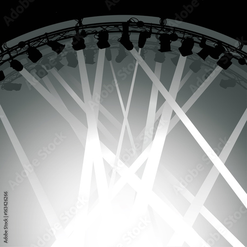 Silhouette of stage lighting rig with beams of light shining down on a stage.
