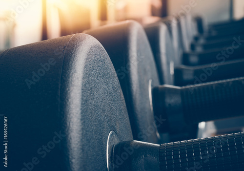 Rows of dumbbells in the gym with hign contrast and monochrome color tone photo