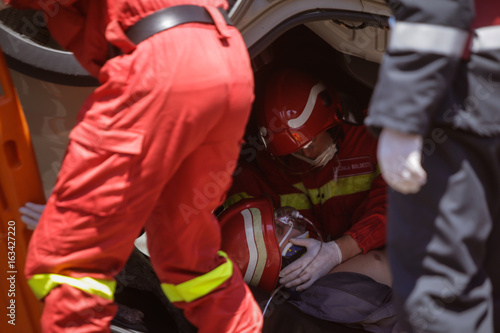 Rescue firefighters and paramedics take part in a vehicle extrication at a drill car crash site photo