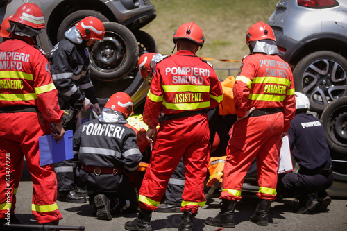 Rescue firefighters and paramedics take part in a vehicle extrication at a drill car crash site
