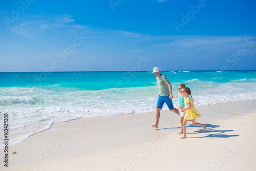 Family on white tropical beach have a lot of fun. Dad and kids enjoy holidays on the seashore. Beach vacation activity