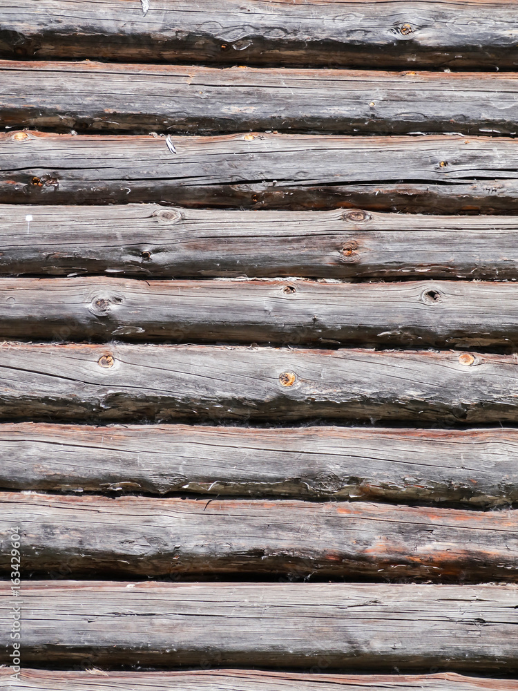 Wall of a wooden house built from logs. Textured background. Wall of a wooden house built from logs. Textured background.