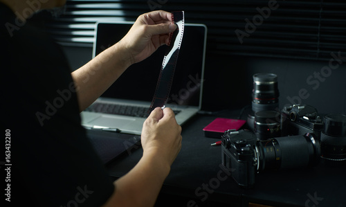 Photographer working checking film negative  ,Stylish home studio concept of hipster . Seleted focus. photo