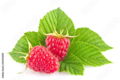Ripe organic raspberry with green leaf isolated on white