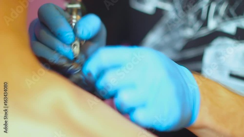 The tattoo artist does the tattoo photo