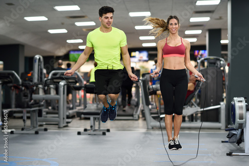 Man and woman workout with jumping rope in crossfit gym